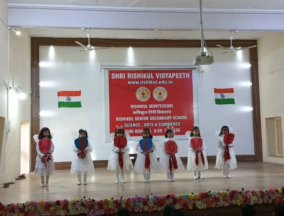 Younger pupils on the flower-decked stage