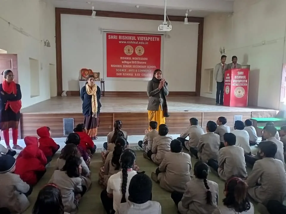 A teacher addressing the school from the hall platform
