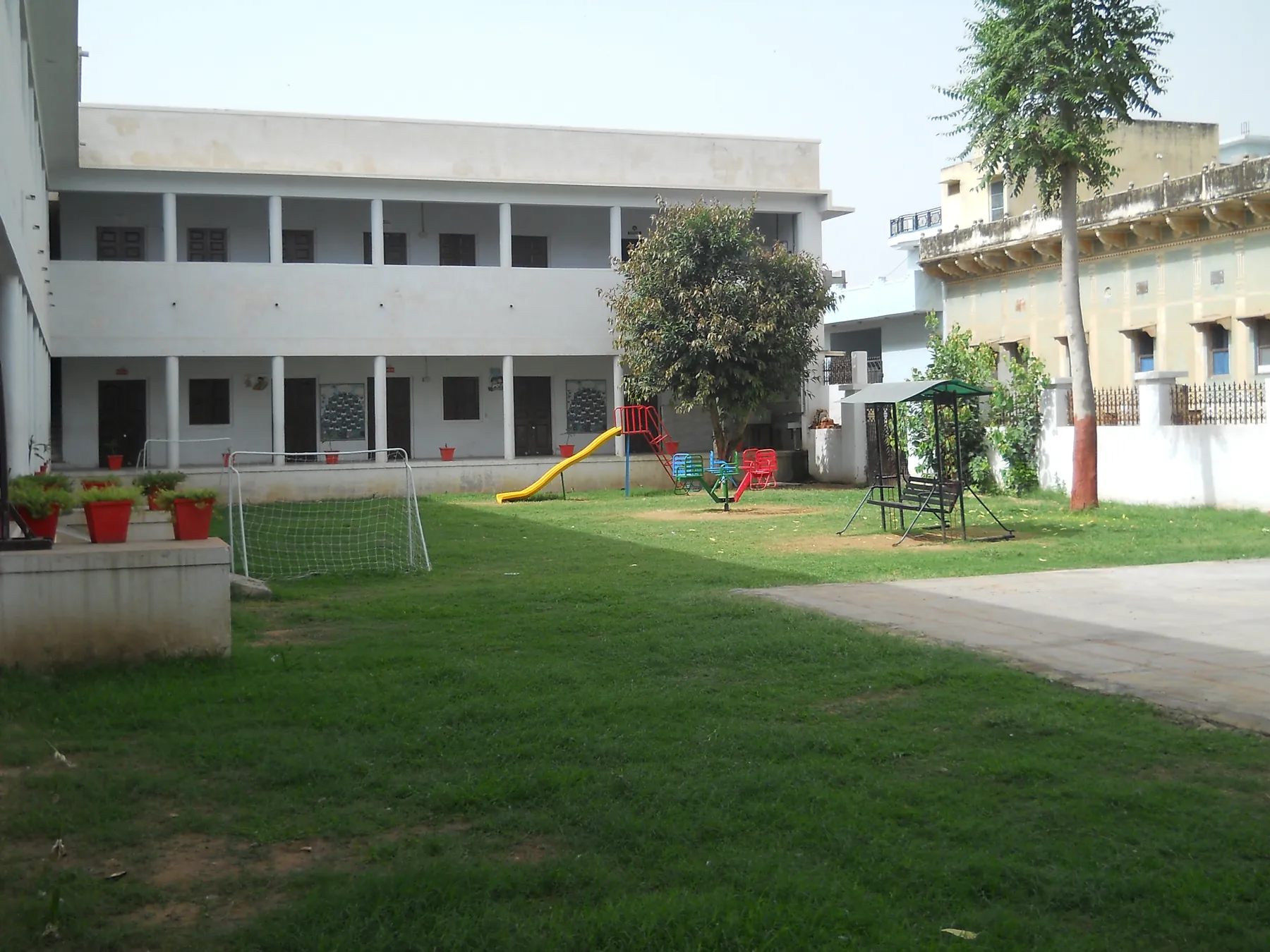 The Rishikul Vidyapeeth courtyard at Laxmangarh, with a painted Shekhawati haveli beyond the wall